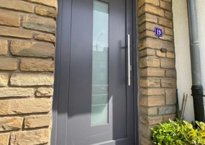 Porte d'entrée grise avec une fenêtre - Châssis Ernst